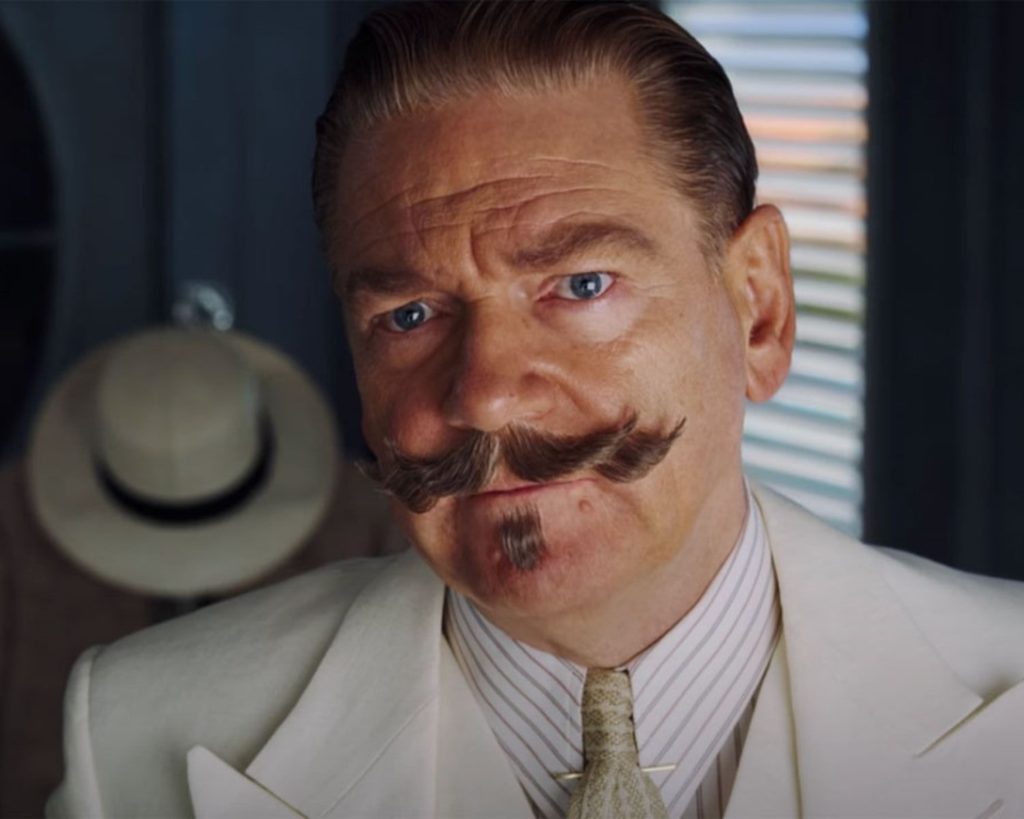 Man with a large mustache wearing a white suit